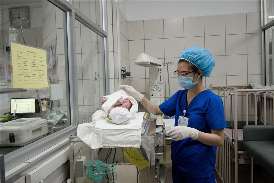 Cán bộ y tế cân đo, kiểm tra sức khỏe cho bé sau khi chào đời. Ảnh: PV