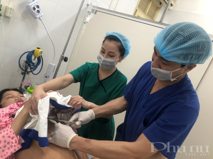 Bác sĩ BV Phụ sản Hà Nội cắt dây rốn cho một em bé chào đời trong ngày 8/4/2020.