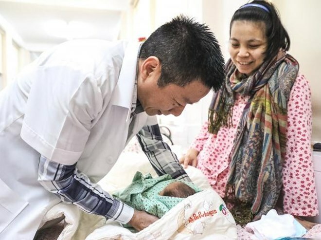 Bác sĩ Khải với một bé sơ sinh tại Bệnh viện Phụ sản Hà Nội. Ảnh: NVCC